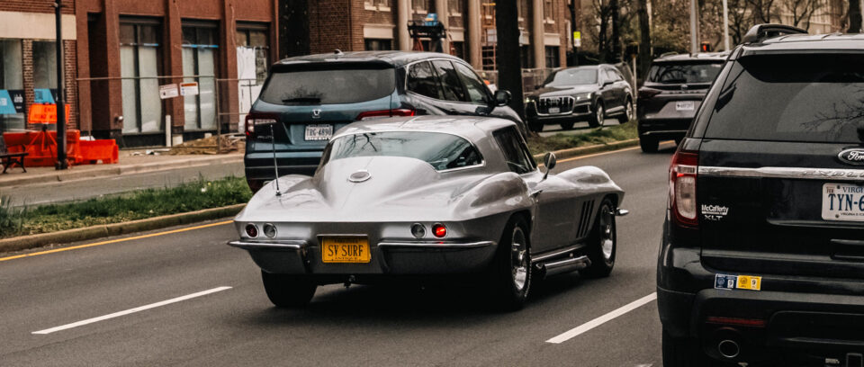 Silver 1970's muscle car driving down street