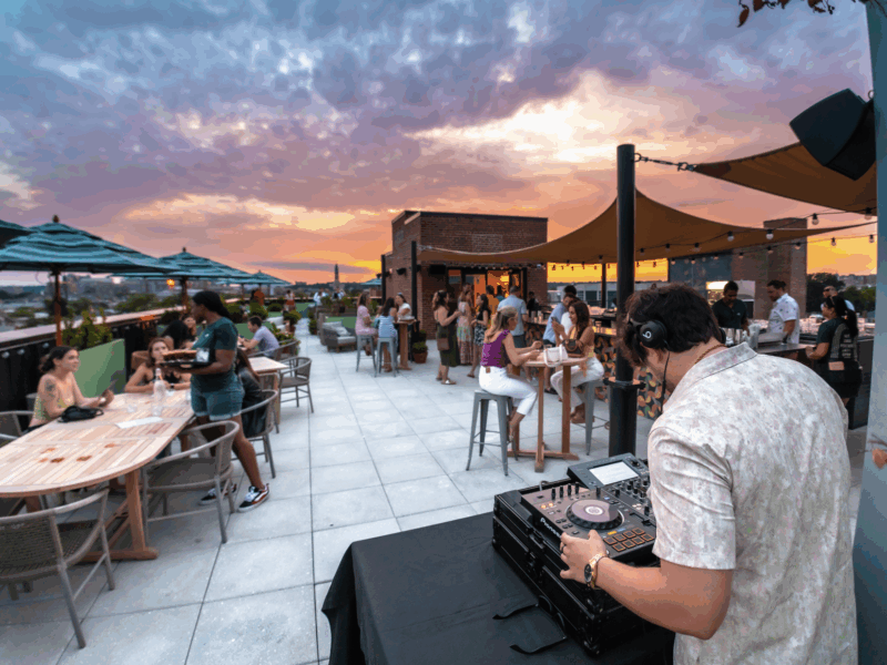Person Djing on roof with crowds in background